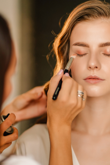 a young woman getting her beauty done by a Maison Helya makeup artist