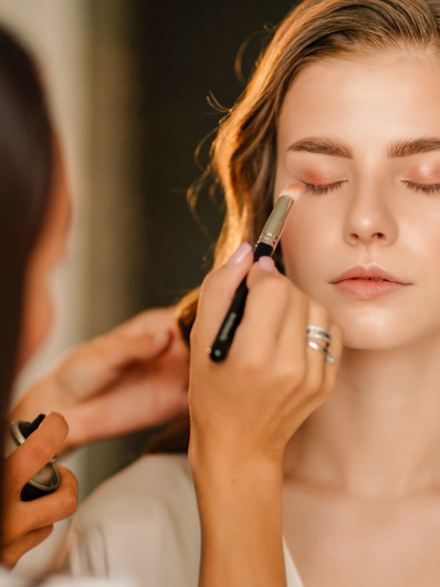 a young woman getting her beauty done by a Maison Helya makeup artist