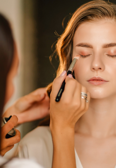 a young woman getting her beauty done by a Maison Helya makeup artist