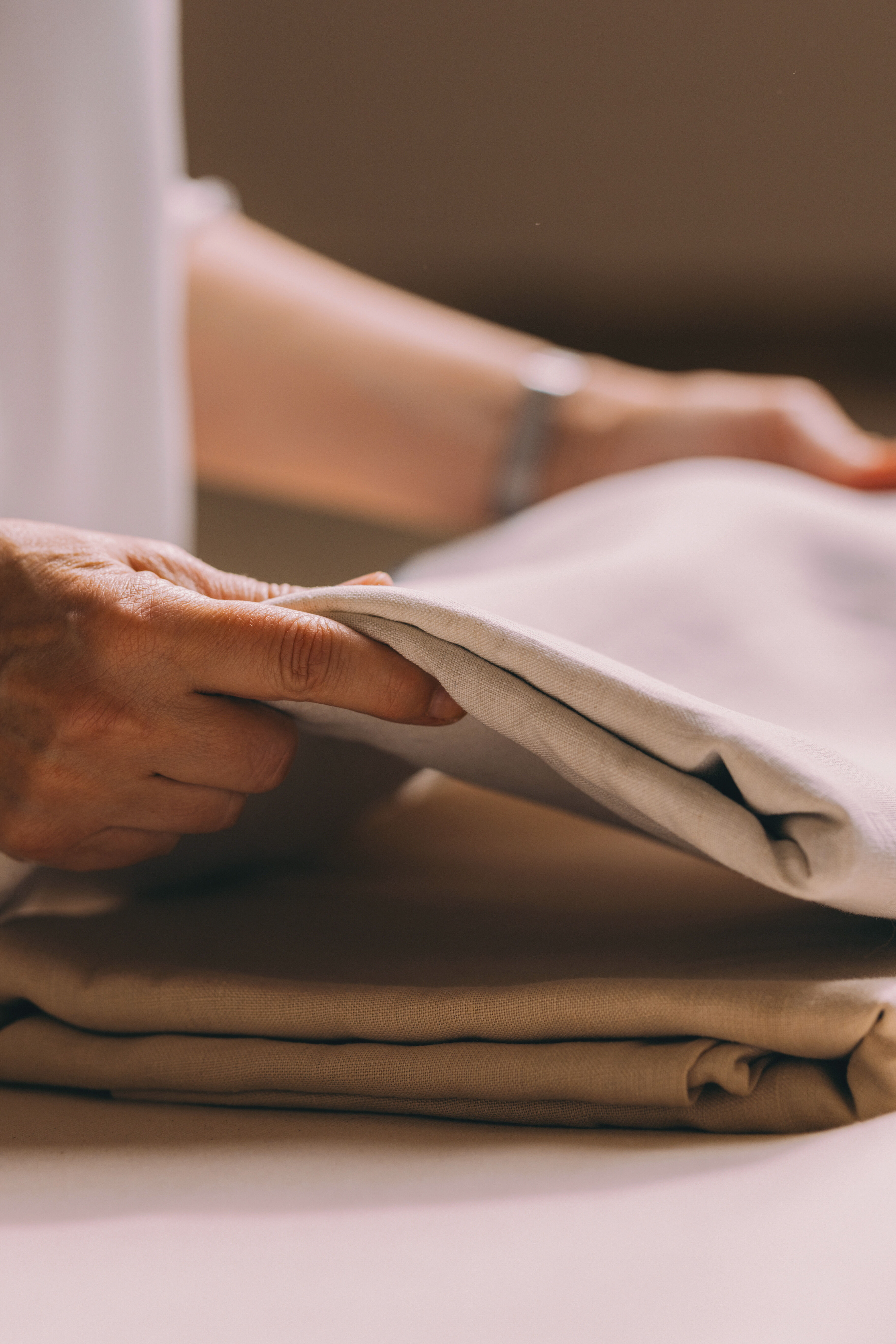 une lingère maison helya plie du linge de maison délicat