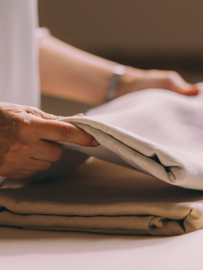 une lingère maison helya plie du linge de maison délicat