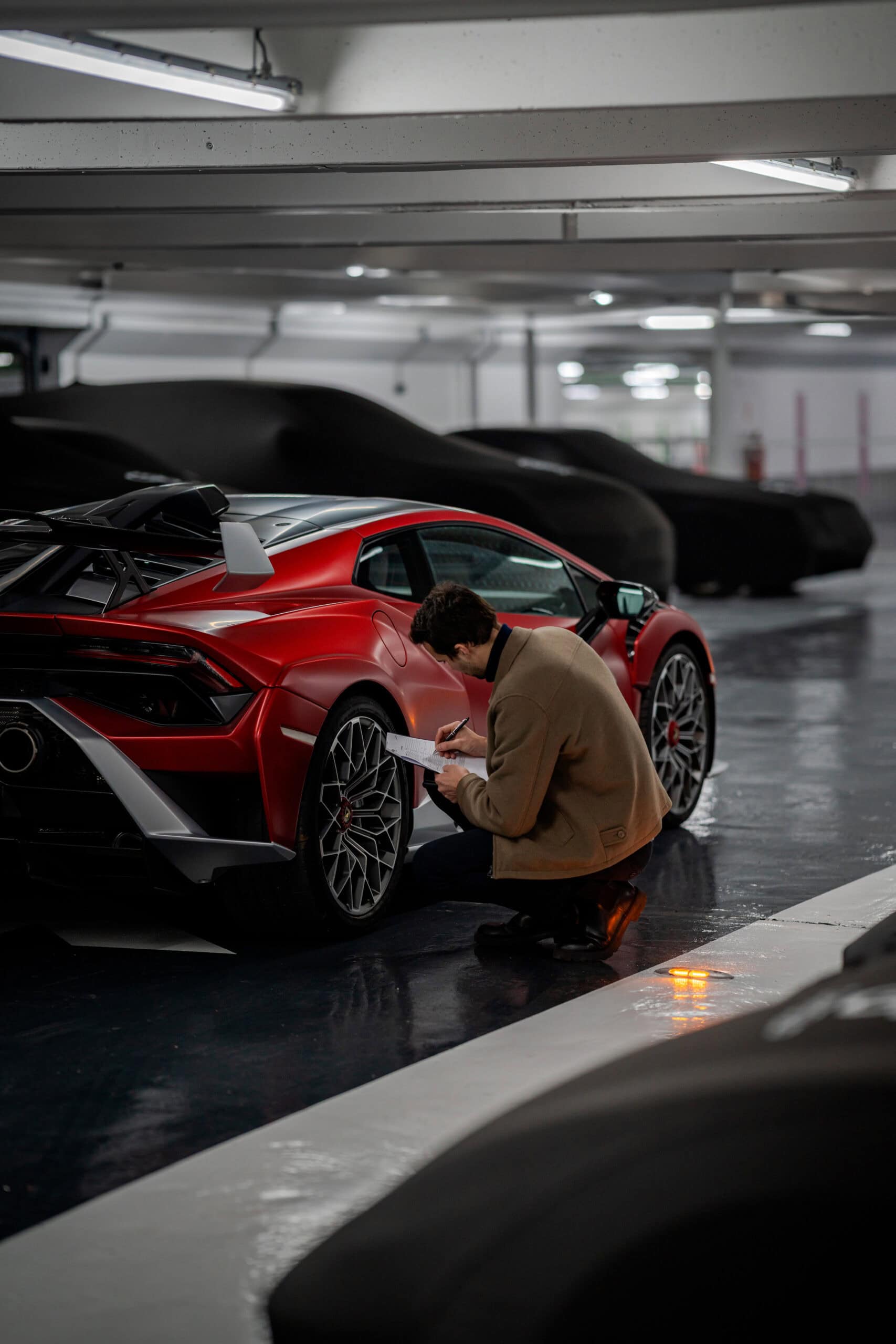 un expertde notre conciergerie automobile partenaire vérifie la voiture de sport d'un client